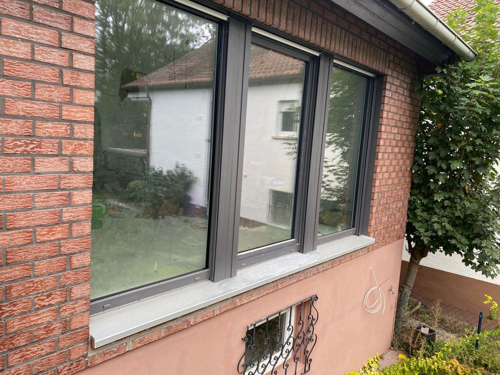 Anthrazitfarbene Fenster in Klinkerfassade